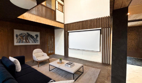 Cozy modern living room with open ceiling and projector in a private Hokkaido villa perfect for family friendly long term stays near Sapporo