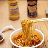 Mouko Tanmen Nakamoto Japanese Spicy Miso Ramen Serving Scene A steaming bite of noodles lifted with chopsticks, showcasing the bold spice and rich flavor of this popular Japanese ramen.